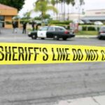Bloody Robbery Stuns West Hollywood yellow sheriff's line tape blocks a street near police cars